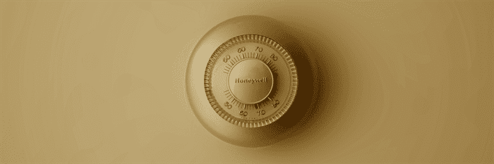 Old dial thermostat on tan wall