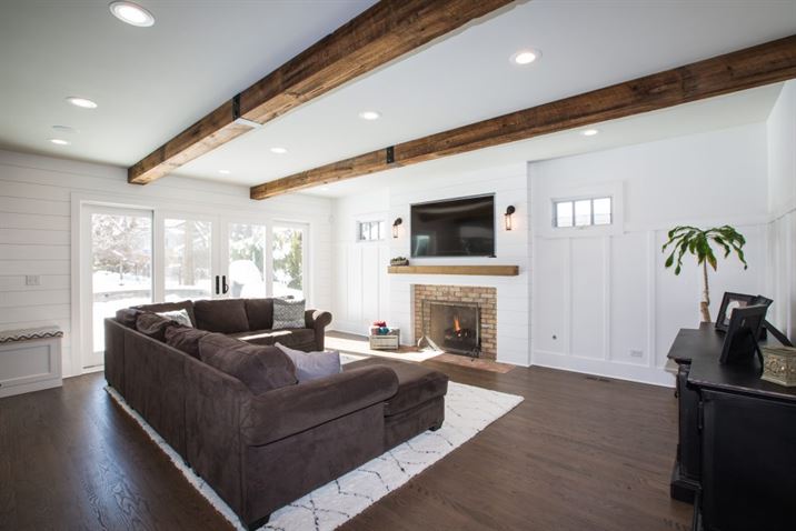 Living room addition with wood beams on ceiling and brick fireplace