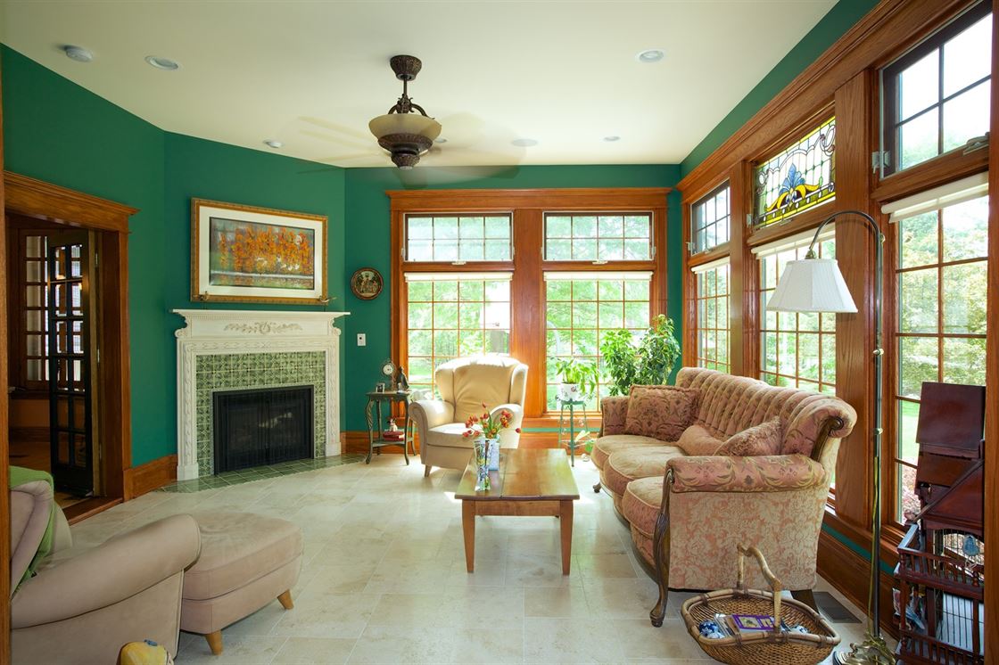 Living room addition with green walls, wood trim, and green tile on fireplace