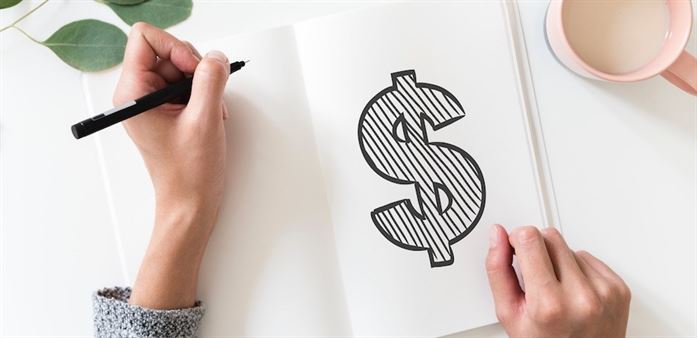 Woman drawing a dollar sign in a notebook