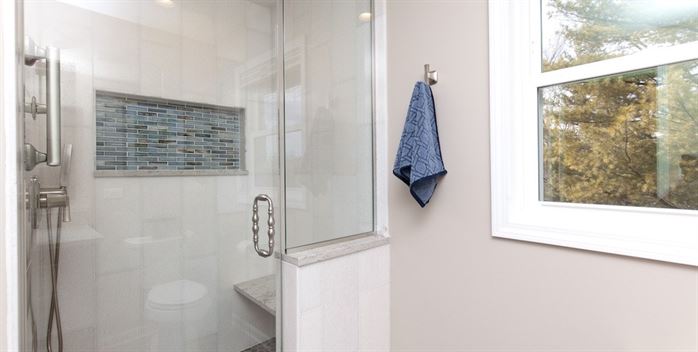 Renovated bathroom with walk in shower and shower seat