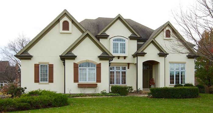 Front of white-colored home with wood shutters and great curb appeal