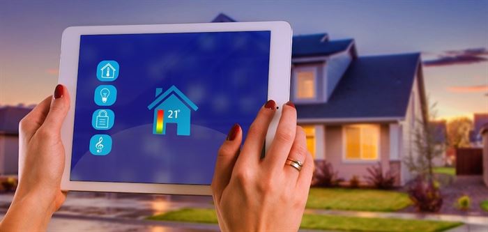 Woman holding iPad controlling the temperature of the house