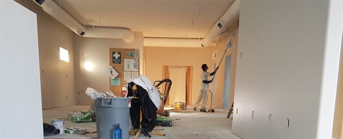 Construction being done to a room and paint being applied to walls