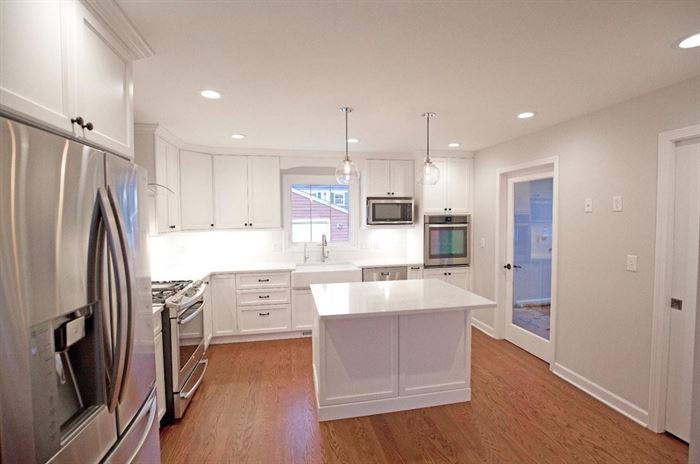 Renovated kitchen with wood floors and white island