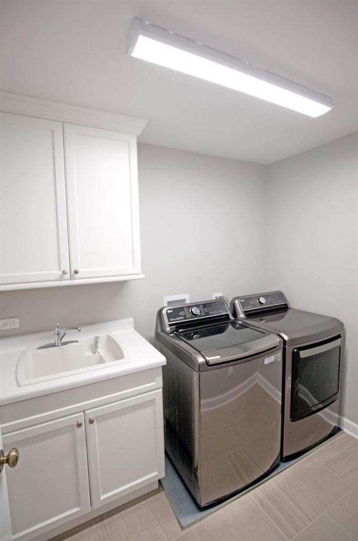 Renovated laundry room with side by side washer and dryer